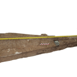 Fig. 4. The tapering end of a knife-shaped cedar plank recovered in 2006 at Mersa/Wadi Gawasis. Visible on its outer face is a through mortise that contains significant remnants of a copper alloy "strap" that would have fastened to an adjoining timber. Along each edge are several paired mortise-and-tenon joints, two of which still contain their original tenons.