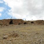 Fig. 7. South-facing Caves 1–4 of Mughr el-Hamamah. Cave 5 (right) is located approximately 30 m to the east. Only Cave 2—the main cave—has substantial in situ prehistoric deposits, and test excavations focused on the front chamber of this cave (courtesy Mughr el-Hamamah Project).