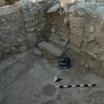 Fig. 49. View of the central hall of Building 306, Khirbat al-Mudayna, facing southeast, showing pillars, doorways, and the foot of a staircase to an unpreserved upper story (courtesy Wadi ath-Thamad Project).