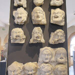 Fig. 5. Fragmentary relief plaques of theater masks, average ht. 27 cm, Chiragan. Toulouse, Musée Saint-Raymond, inv. nos. Ra 35 (1) to (12).