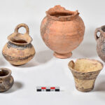 Fig. 6. Ceramic vessels from Tomb 11 outside the southeast corner of the Blue Stone Structure; front row, left to right: Gray Minyan squat juglet (P1921), Gray Minyan pyxis (P1916), two matte-painted Vapheio cups (P1917, P1922); back row, left to right: two matte-painted vertical ring-handled cups (P1851, P1908), bichrome jug (P1915), amphoriskos (P1920).