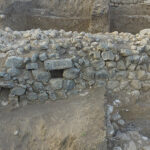 Fig. 11. Close-up high view of the previously unknown city wall of Level V in Area CC, facing south. Note the opening of a drainage system (E. Aladjem, Israel Antiquities Authority).