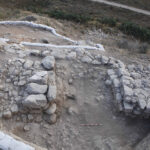 Fig. 18. The Level II city wall and gate leading down to the valley on the eastern slope of Area BB. White sandbags secure the balks.